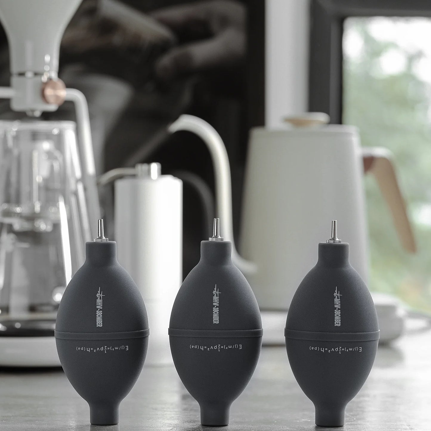 MHW-3BOMBER grey air blowers for coffee on a counter. Silicone and stainless steel.