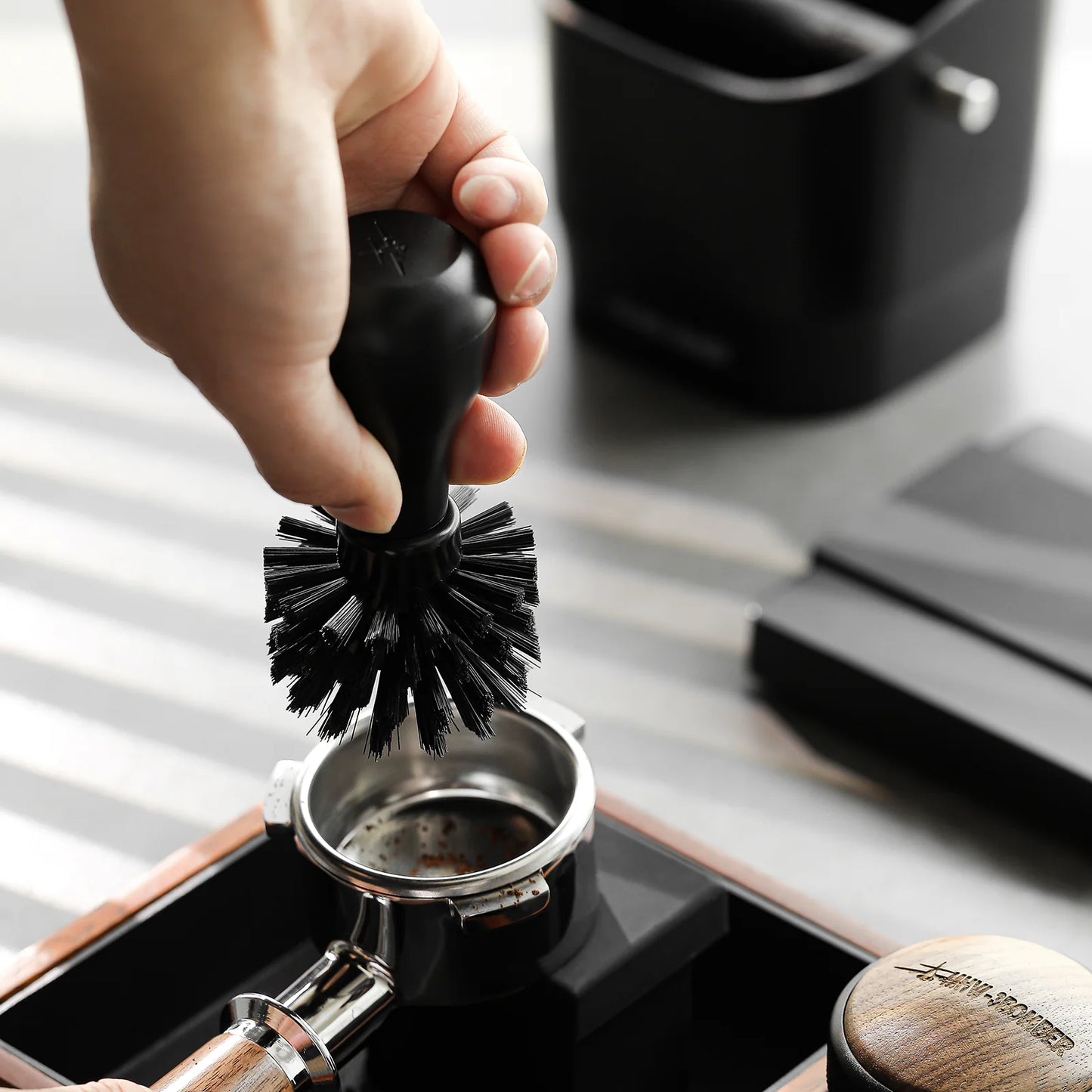 MHW-3BOMBER black portafilter cleaning brush in use. ABS handle with nylon bristles.