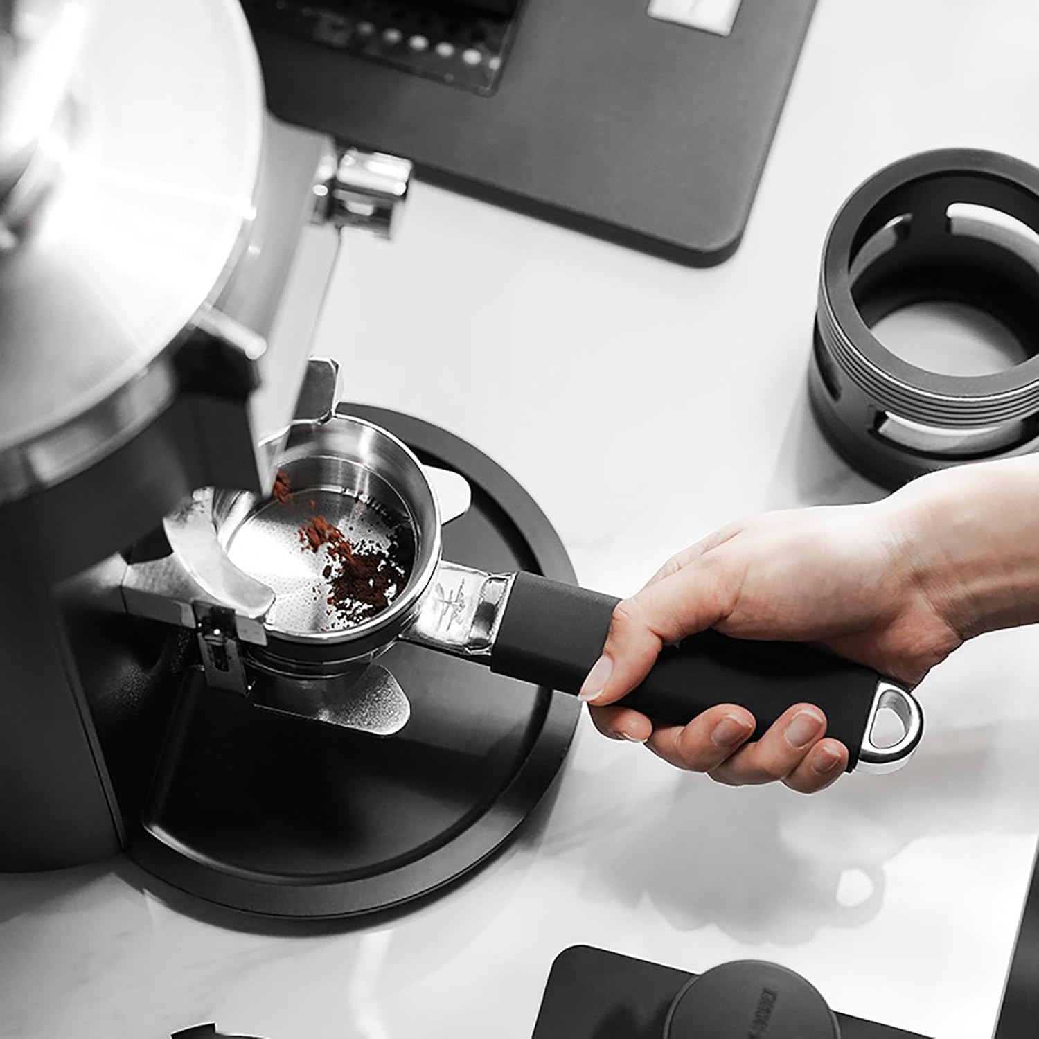 Person using a manual coffee grinder with a focus on the coffee beans.