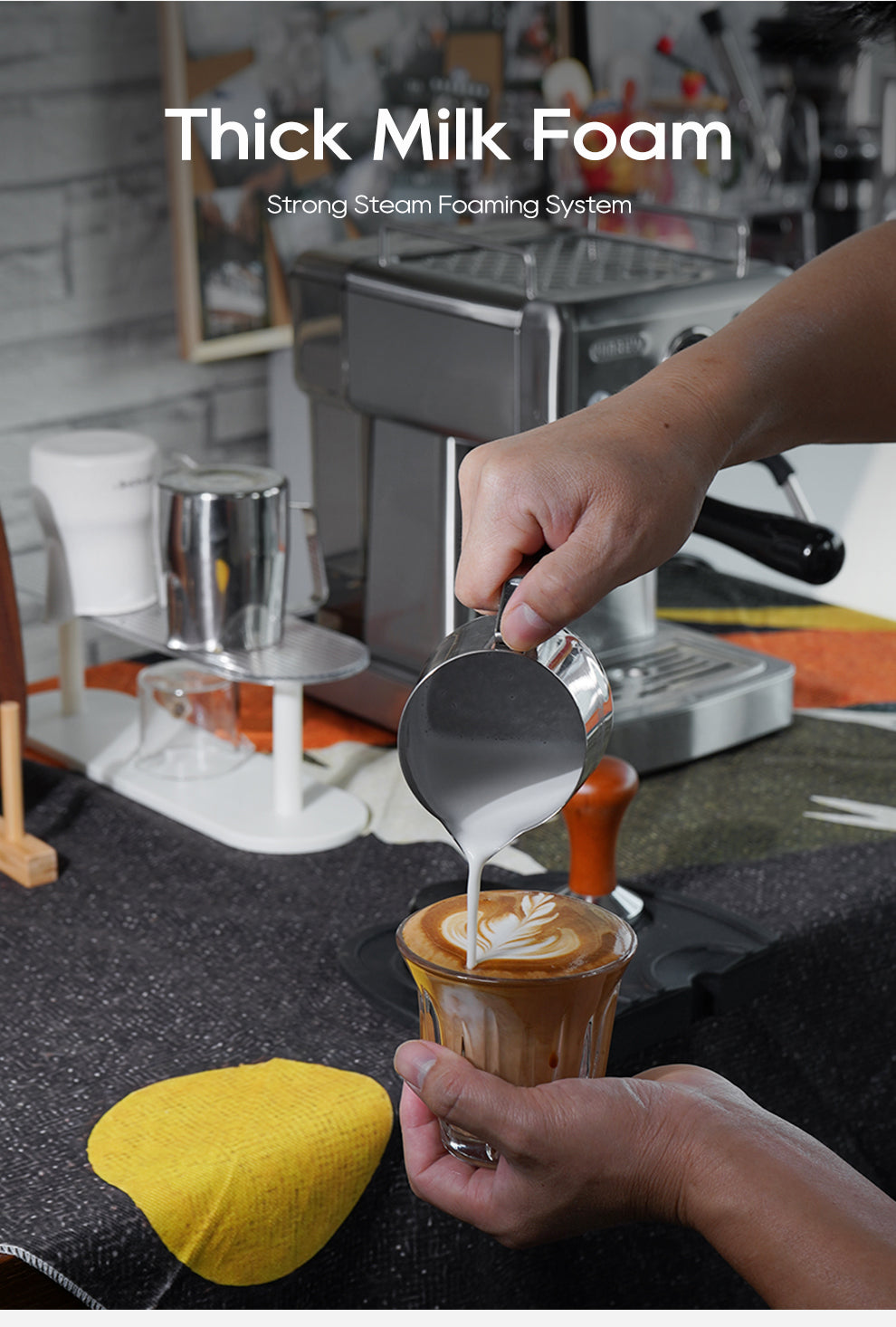 A person pours milk foam from a metal jug to create latte art, capturing the home barista spirit. The HiBREW H10A Espresso Coffee Machine with Temperature Adjustment and various tools complete the scene. The image is titled Thick Milk Foam: Strong Steam Foaming System.