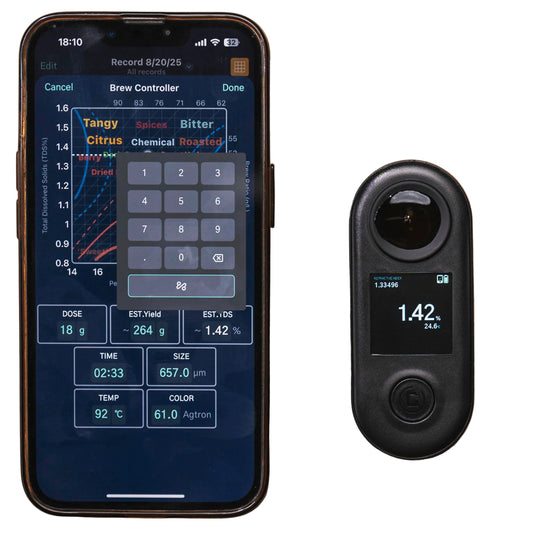 Smartphone displaying a coffee brewing app next to a coffee quality measurement device on a wooden surface.