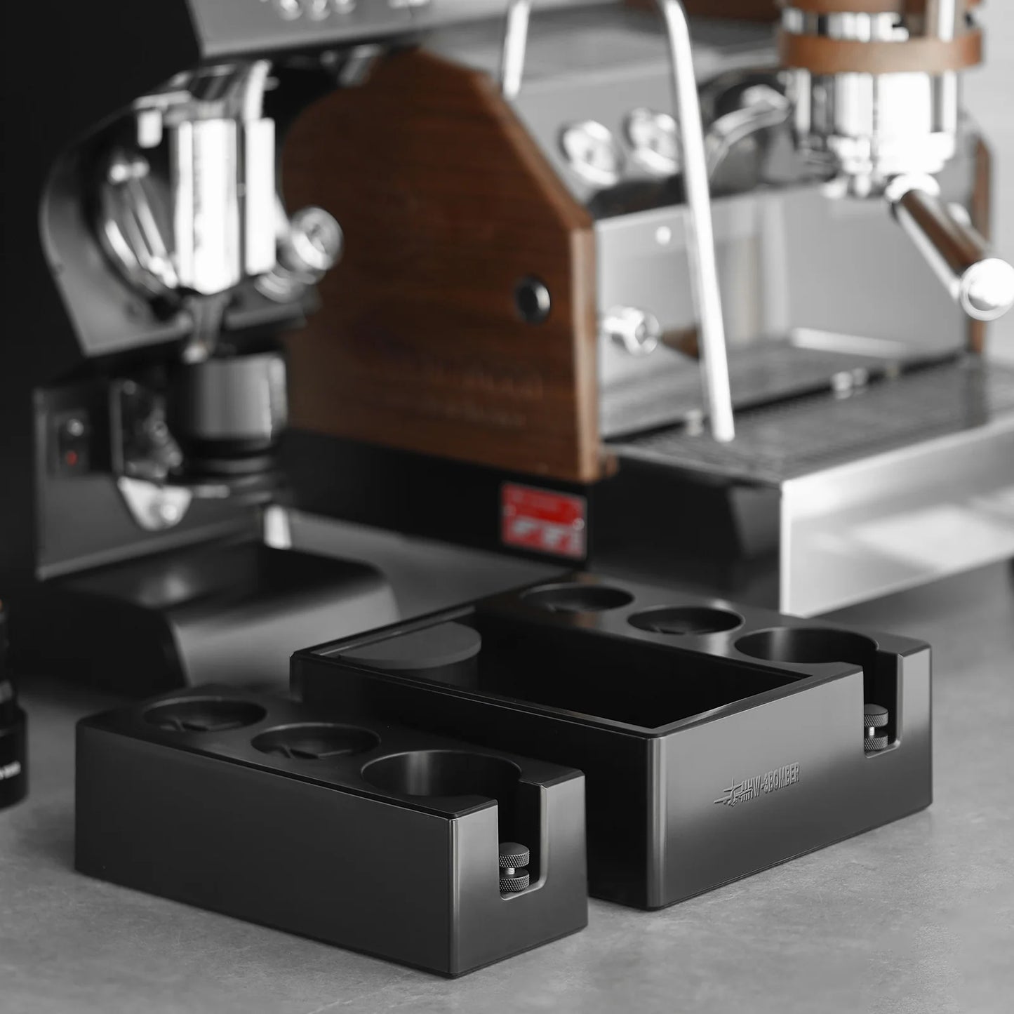 MHW-3BOMBER black ABS portafilter holder/tamper station for 51-58mm portafilters. Adjustable height, easy to clean.