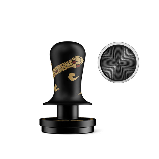 MHW-3BOMBER Flash constant pressure tamper in black with a gold snake motif, beside its base disc
