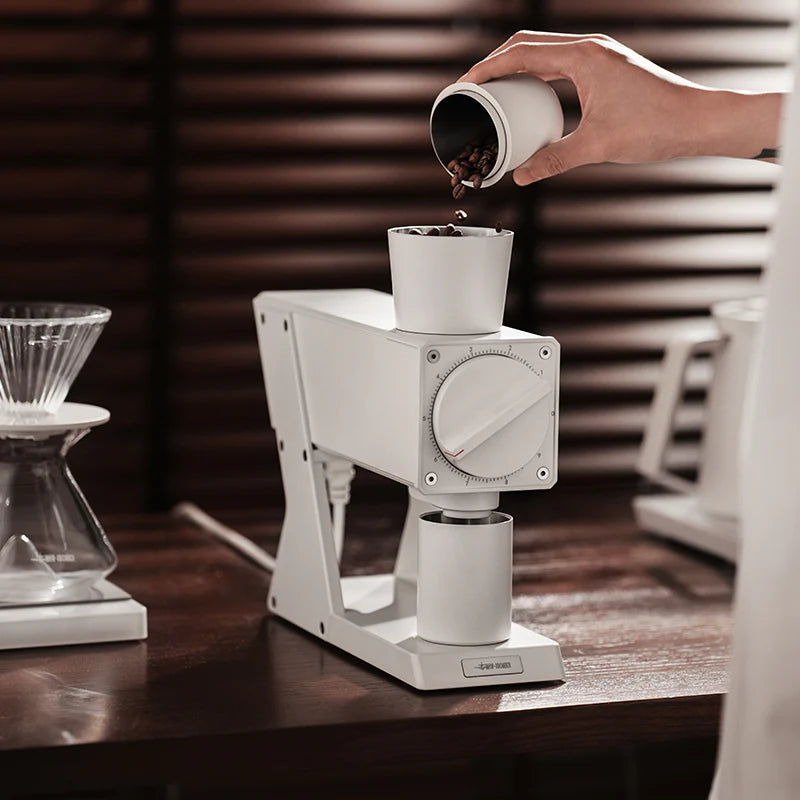 MHW-3BOMBER F74 Navigator coffee grinder in white. Pouring coffee beans in. Precise grind control.