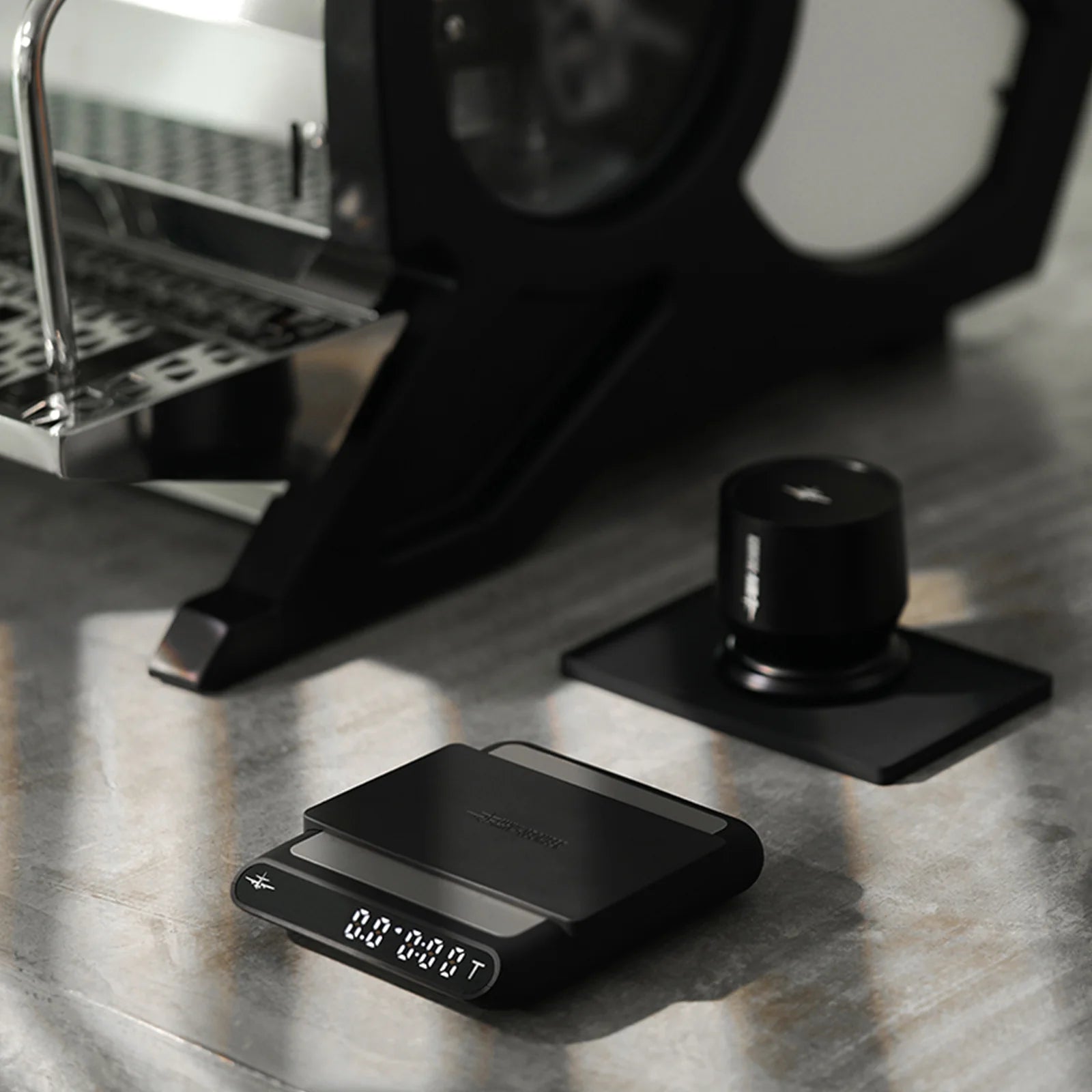 MHW-3BOMBER black smart espresso scale with timer and automatic liquid detection on a kitchen counter.