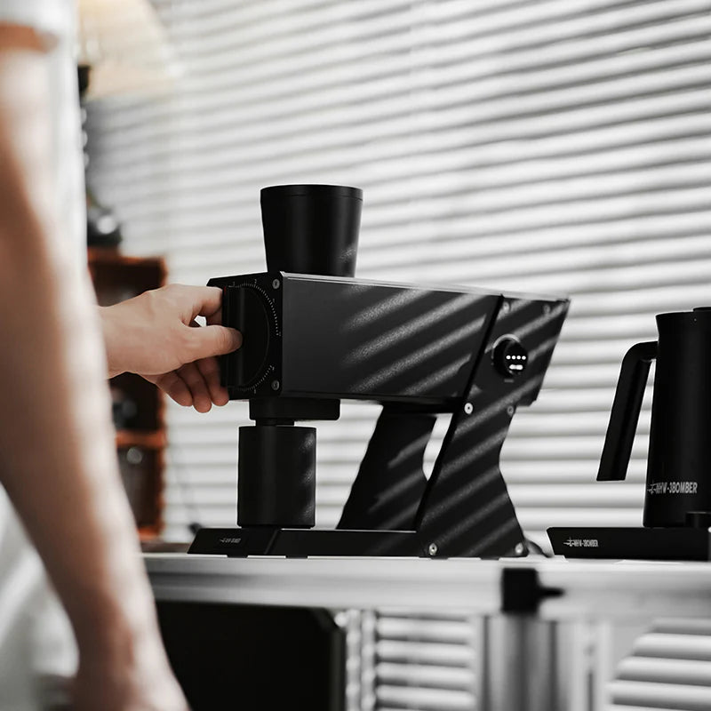 MHW-3BOMBER F74 black electric coffee grinder. Features include titanium flat burrs, smart modes, and stepless adjustment.