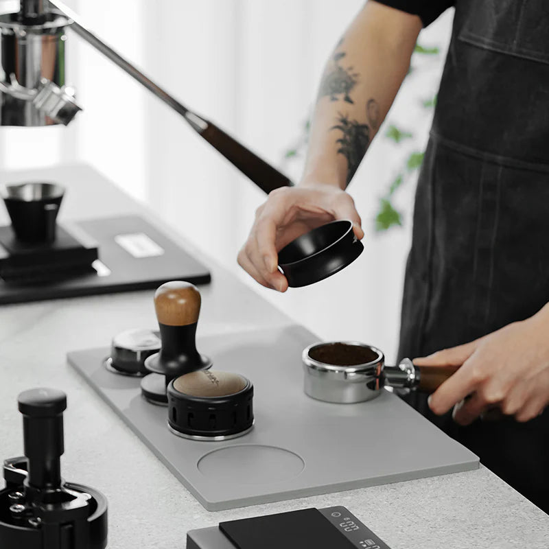 MHW-3BOMBER YU Series tamping base in gray with portafilter, tamper, and distributor slots. Organized coffee station.