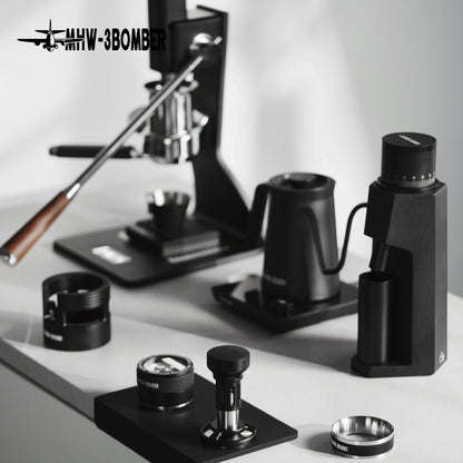 MHW-3BOMBER espresso setup: manual press, grinder, kettle, and tamper. Black finish. 