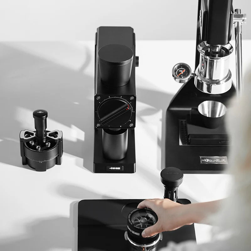 MHW-3BOMBER F74 black electric coffee grinder and portafilter. 74mm burrs and dial shown. 