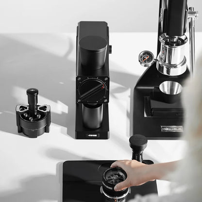 MHW-3BOMBER F74 black electric coffee grinder and portafilter. 74mm burrs and dial shown. 
