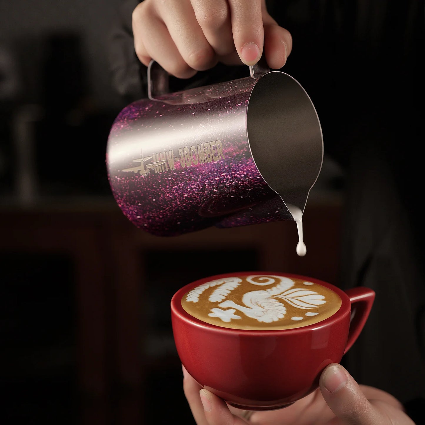 MHW-3BOMBER purple latte art pitcher pouring into a red cup. Latte art in progress. 