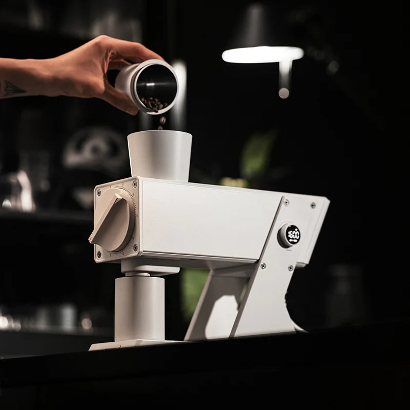 MHW-3BOMBER white electric coffee grinder shown in use, filling with beans. Precise, digital display. 