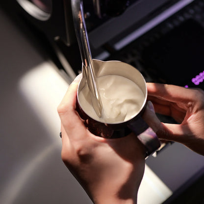 MHW-3BOMBER purple latte art pitcher with crocodile spout, being used to froth milk.