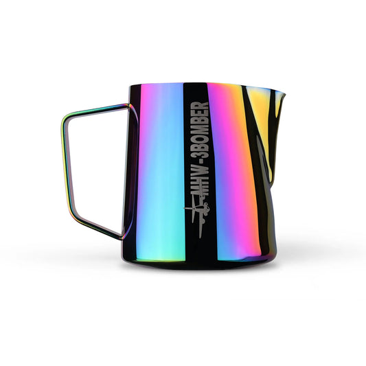The MHW-3BOMBER Latte Art Pitcher 5.0 Colorful is a shiny, reflective milk foamer cup with a colorful, iridescent finish, featuring a square handle and an engraved graphic of a small bomber plane alongside the words MHW-3BOMBER on its stainless steel side.