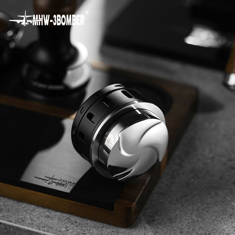 MHW-3BOMBER Falcon gravity coffee distributor. Black and silver espresso leveler on a wooden base. 