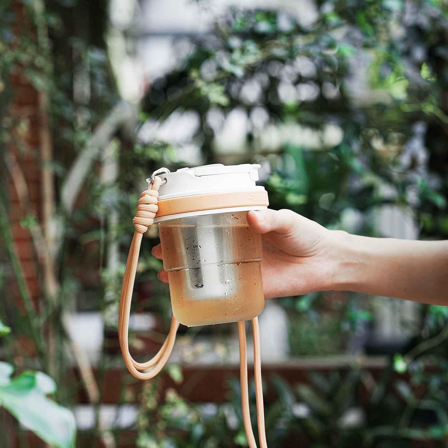 MHW-3BOMBER cold brew cup with strap. Portable, transparent, with filter. Held in hand.