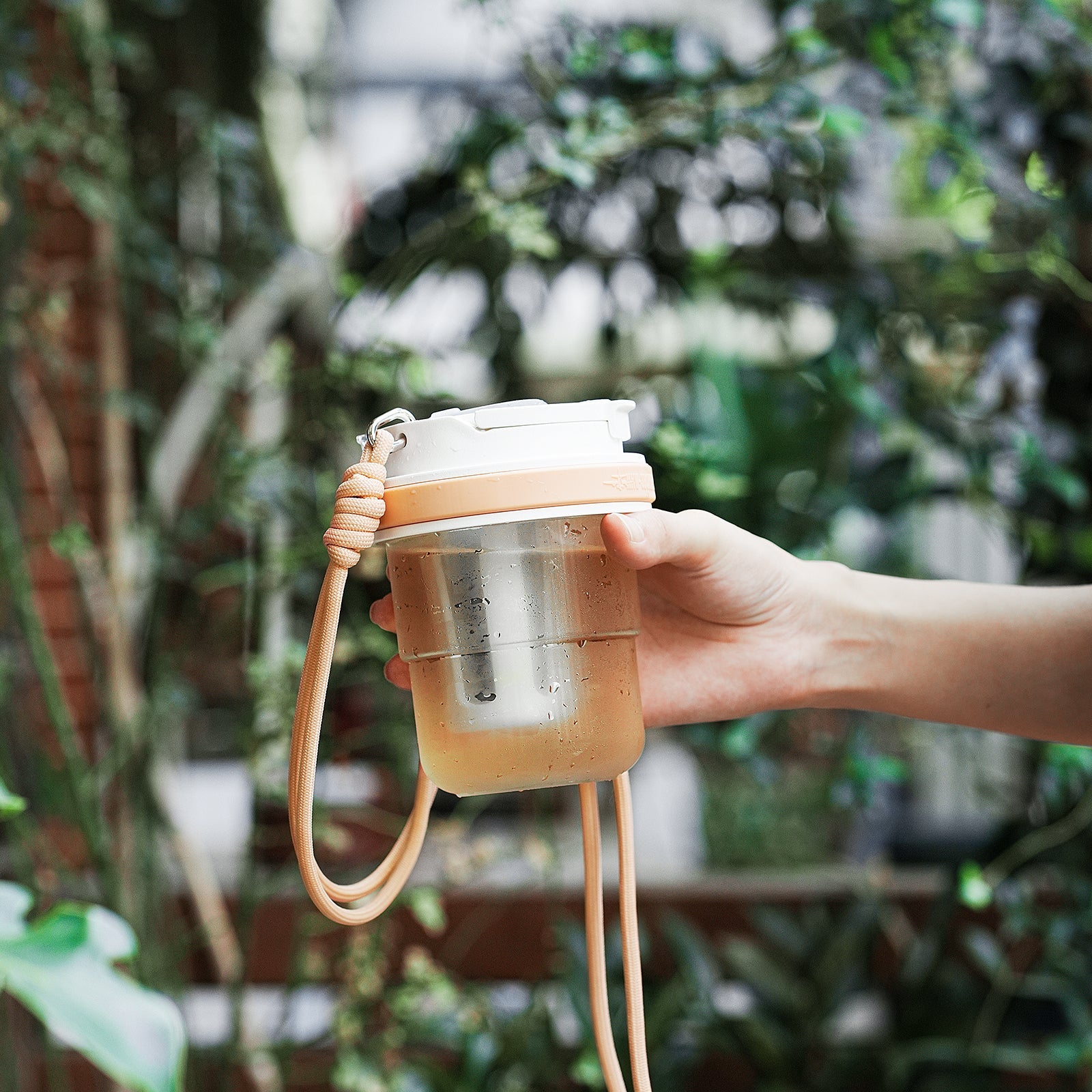 MHW-3BOMBER cold brew cup with strap. Portable, transparent, with filter. Held in hand.