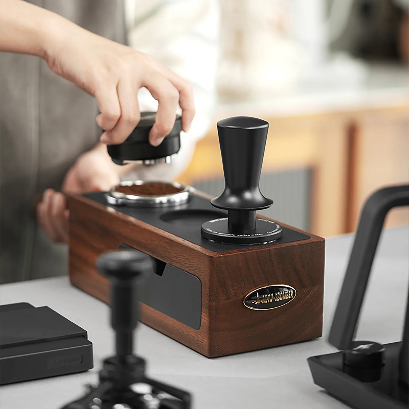 MHW-3BOMBER tamper station with black tamper. Walnut wood base. Coffee tamping in progress.