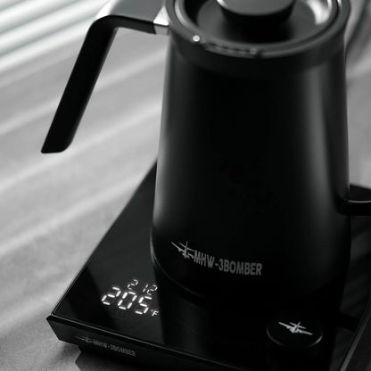 MHW-3BOMBER black gooseneck kettle on digital scale displaying 205°F. Precise pour control, stainless steel. 