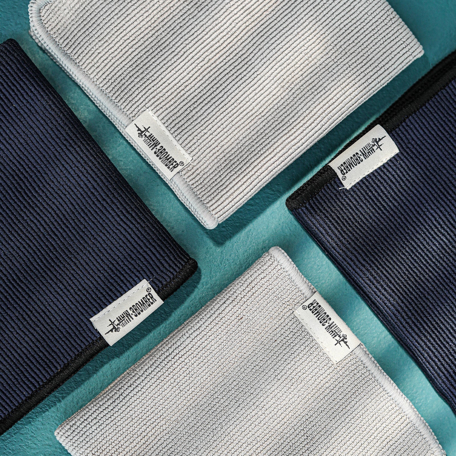 MHW-3BOMBER barista towels set in blue and gray. Textured, labeled close-up.