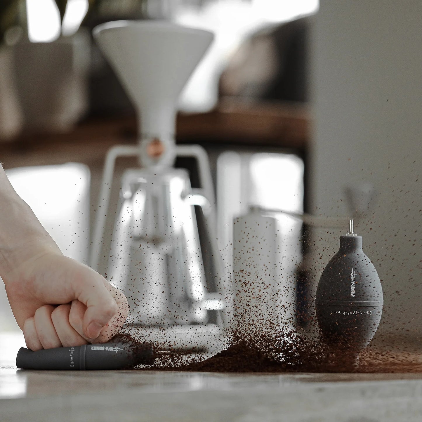 MHW-3BOMBER grey coffee air blower cleaning grounds on a counter. Filter, stainless nozzle.