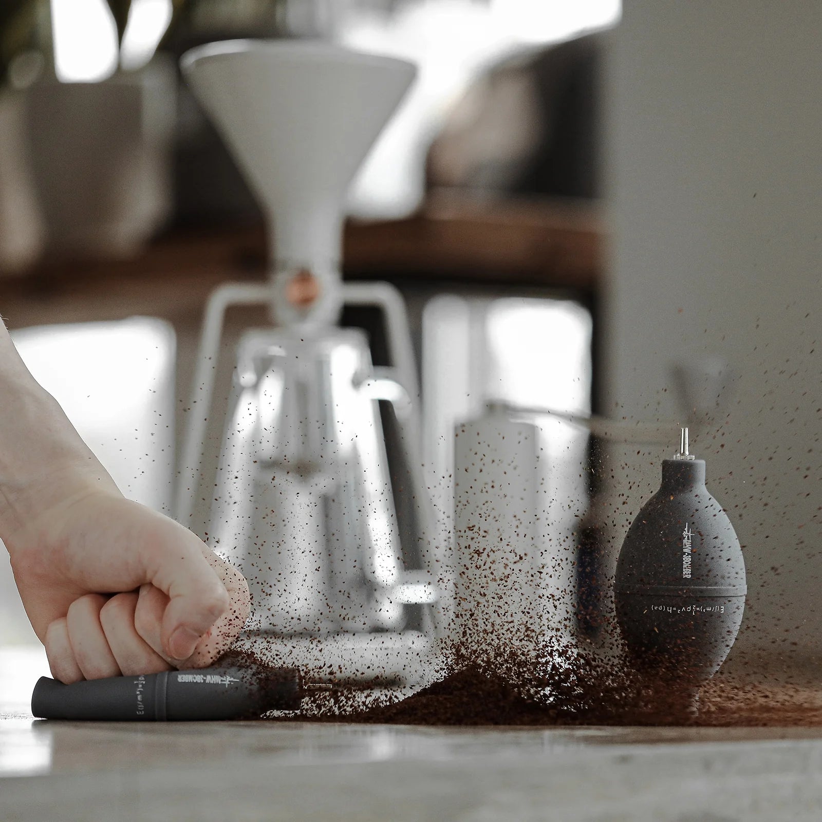 MHW-3BOMBER grey coffee air blower cleaning grounds on a counter. Filter, stainless nozzle.