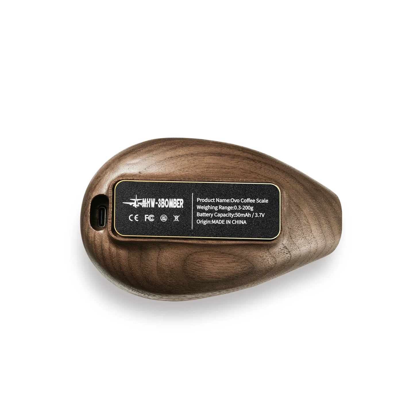 The MHW-3BOMBER Ovo Coffee Scale & Spray Bottle Set features a sleek, wooden espresso scale with a rounded design and product label. It includes weight range, battery capacity details, and USB port. Ideal for precise brewing, it is made in China.