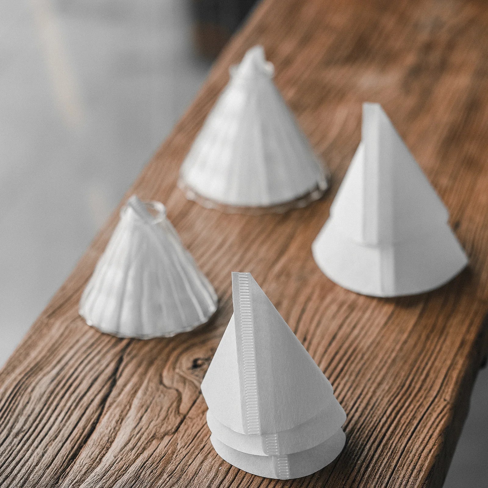 MHW-3BOMBER cone coffee paper filters, white, on wood surface. Single-use, versatile for 1-4 cup drippers.