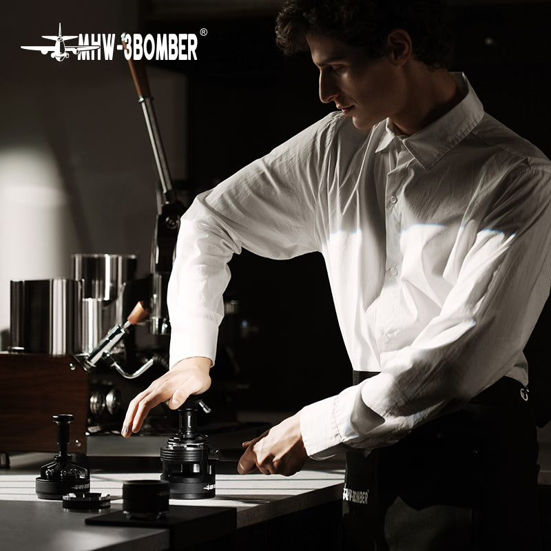 MHW-3BOMBER 58mm espresso tamper in use. Black, force impact design. Professional barista tool.