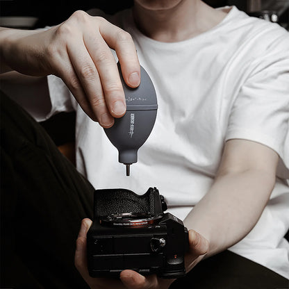 MHW-3BOMBER grey air blower used on camera lens. Silicone, stainless steel nozzle.