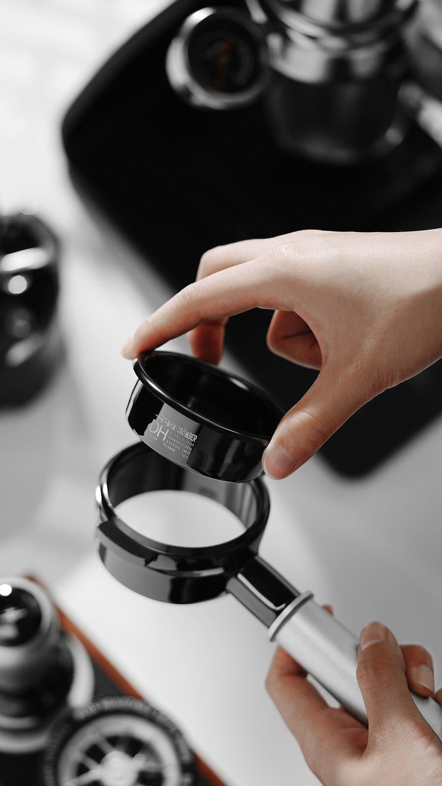 MHW-3BOMBER DH Filter Basket, 58mm. Black portafilter being filled. Perfect for medium-dark roasts.
