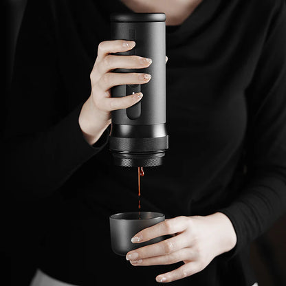 Person pouring coffee from a portable coffee maker into a cup.