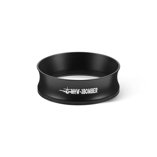 The MHW-3BOMBER Espresso Magnetic Coffee Dosing Funnel is a black metal ring featuring MHW-3BOMBER and a small airplane in white. Its slightly flared design stands out on the white background.