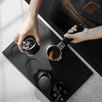 MHW-3BOMBER black silicone tamping base with portafilter, tamper, and WDT tool slots. For organized coffee station.