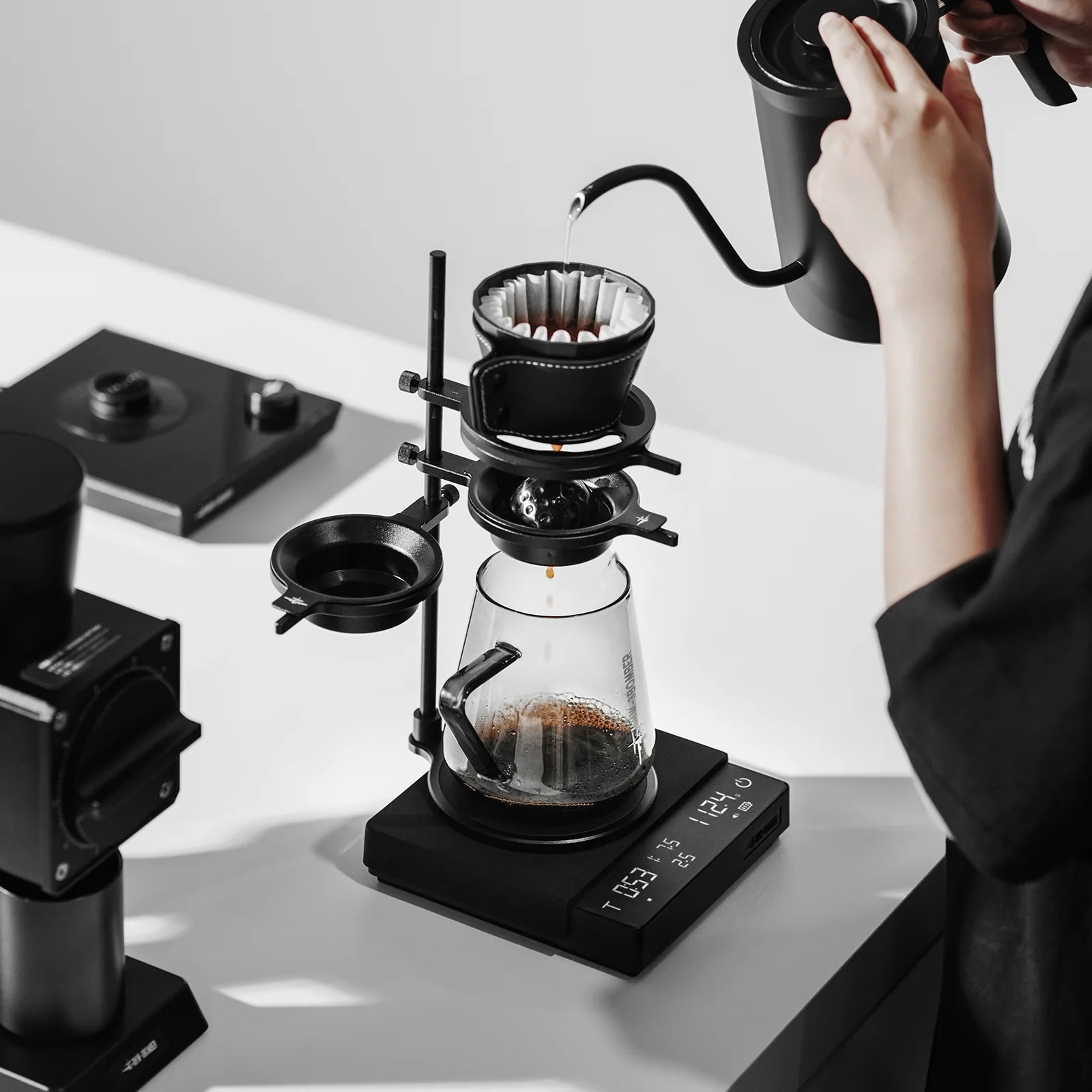 Pour-over coffee being made with black MHW-3BOMBER Cube Coffee Scale 3.0 Pro Max, kettle, and brewing setup.