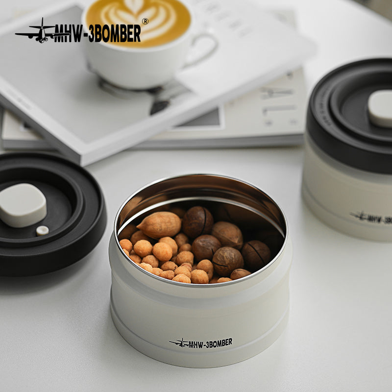 MHW-3BOMBER vacuum canister with nuts inside. White canister with black lid. Sealing design, circle bottom.