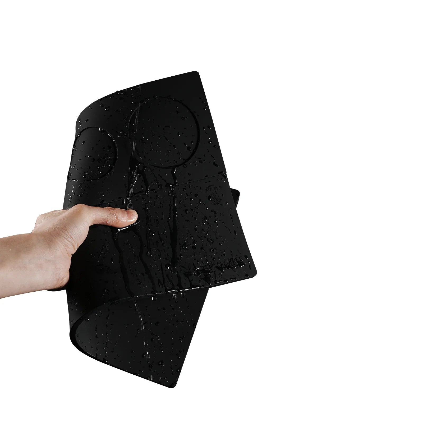 MHW-3BOMBER YU Series black silicone tamping base mat with portafilter slots, water-resistant, held in hand.
