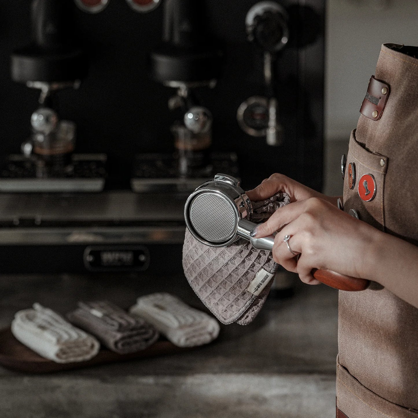Cafe Luxe barista wiping portafilter with a lavender waffle towel. Daily Cleaning Essentials Kit.