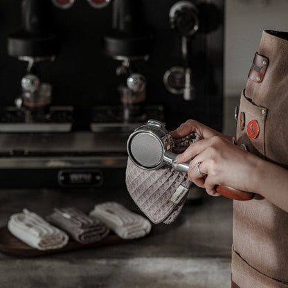 Cafe Luxe barista wiping portafilter with a lavender waffle towel. Daily Cleaning Essentials Kit.