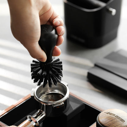 MHW-3BOMBER black portafilter cleaning brush in use. ABS handle with nylon bristles. 