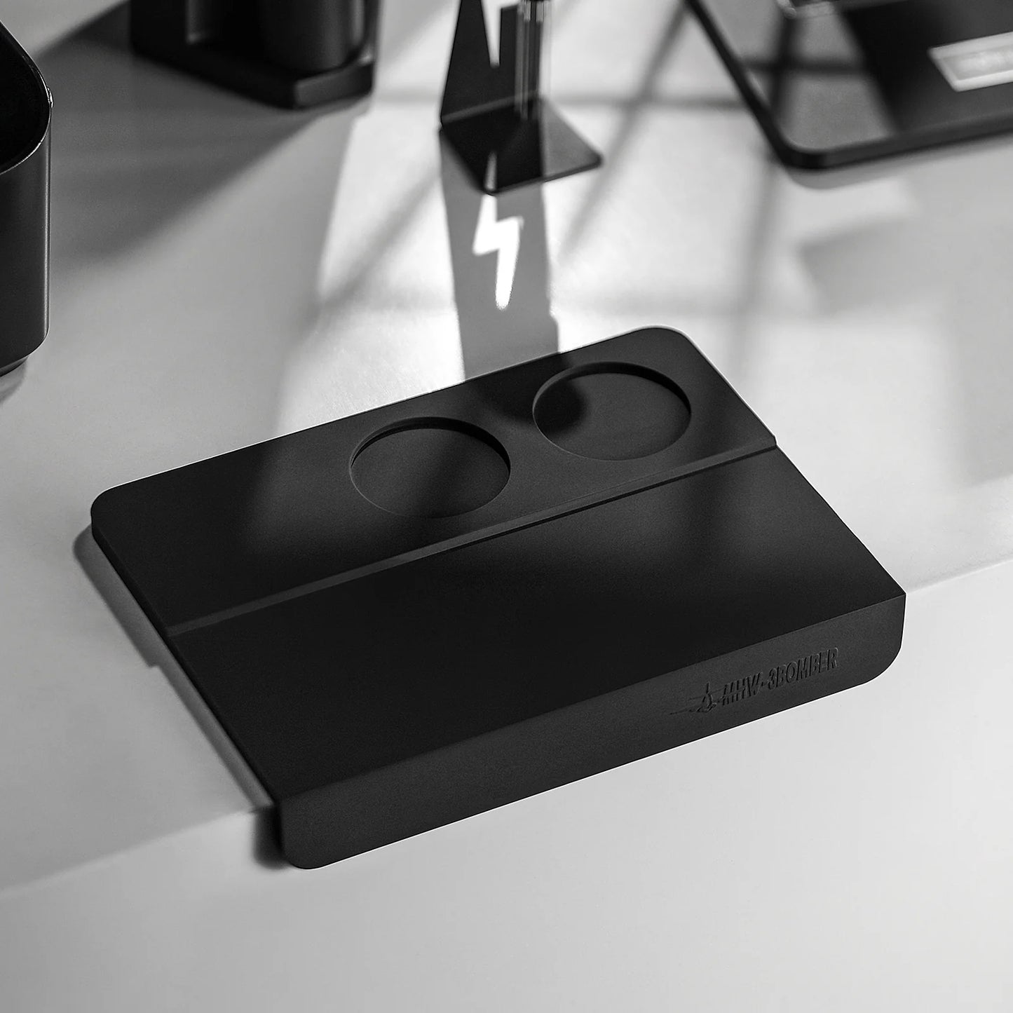 MHW-3BOMBER black silicone tamper mat with two holes for espresso portafilter. Protects counters during tamping.