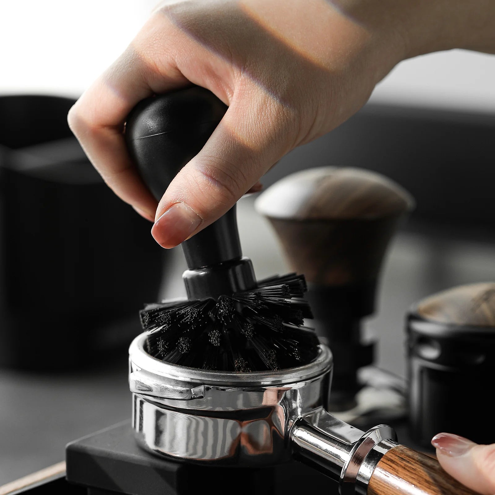 MHW-3BOMBER black portafilter cleaning brush in use with 58mm portafilter. Close up view of black bristles.