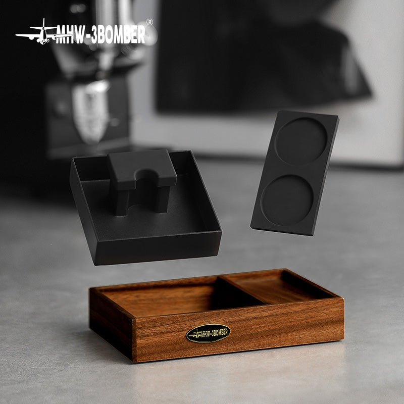 MHW-3BOMBER espresso tamping station with wood base, black portafilter holder, and tamping mat.