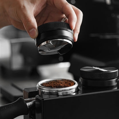 MHW-3BOMBER coffee distributor being used. Black & steel, adjustable height. Professional espresso tool.