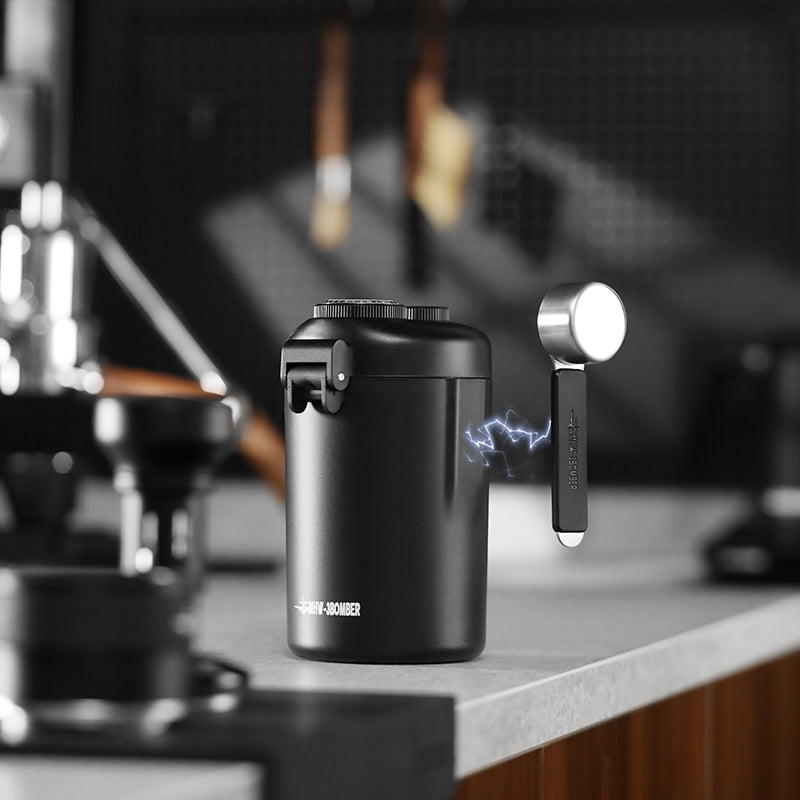 MHW-3BOMBER black coffee canister with magnetic spoon. One-way valve. Date recording discs. On kitchen counter.