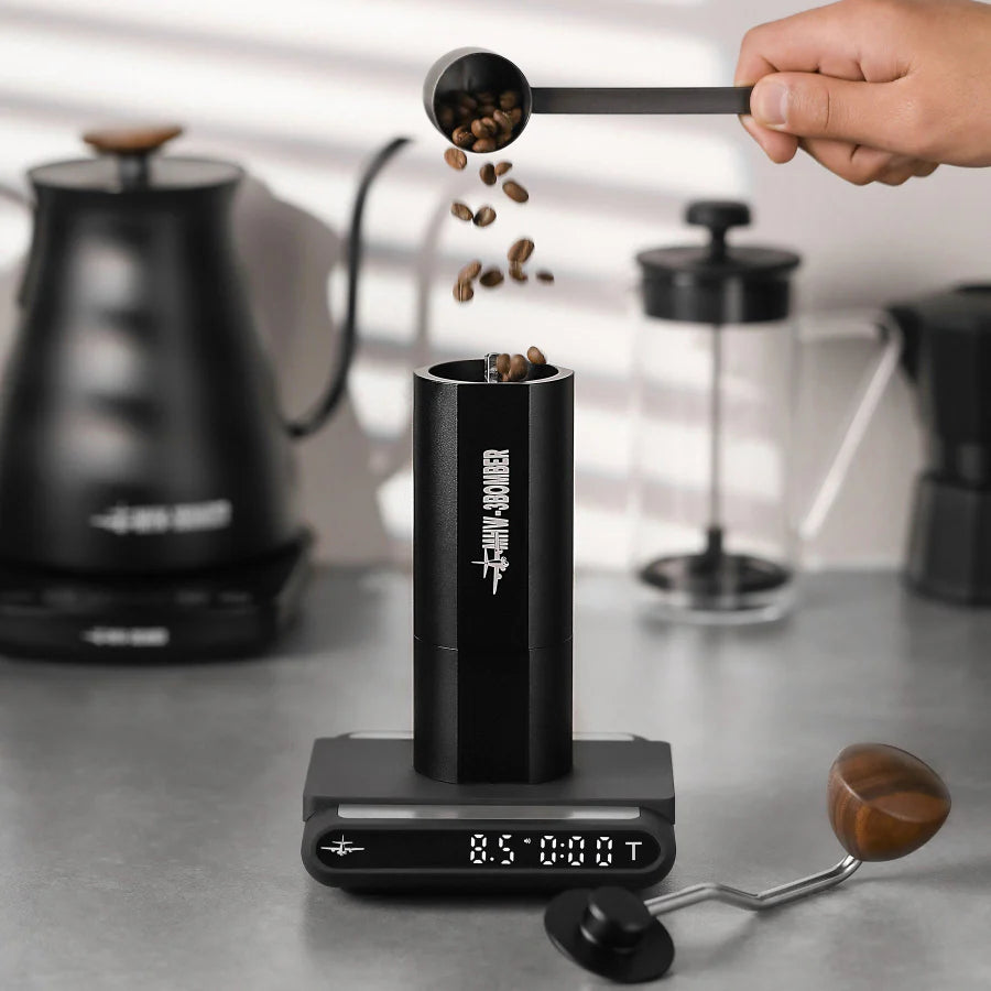 MHW-3BOMBER black manual coffee grinder on scale as beans are poured. Point-to-point adjustment.