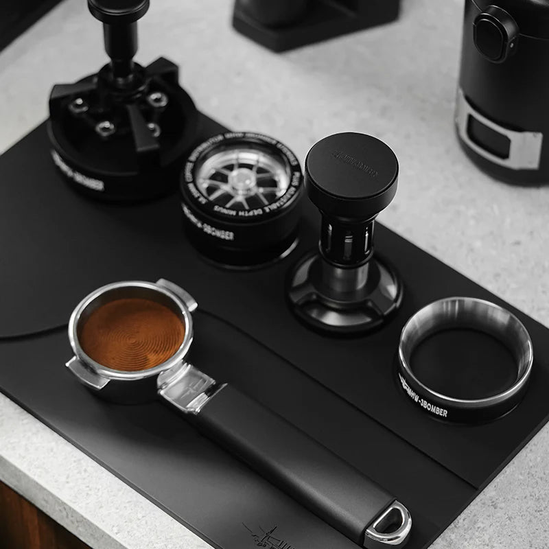 MHW-3BOMBER black silicone tamping base with portafilter, tamper, distributor and dosing funnel slots.