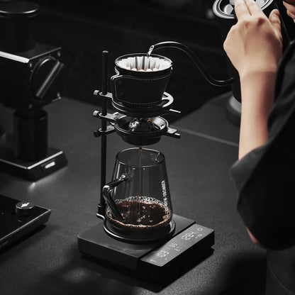 MHW-3BOMBER Cube Coffee Scale 3.0 Pro Max in use. Black scale with pour-over setup on top. 