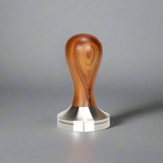 The HiBREW Steel Tamper with a wooden handle stands upright on a gray surface, enhancing your coffee experience. Its smooth, natural wood grain pattern is perfect for crafting espresso shots with precision.