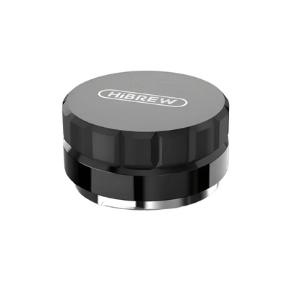 The HiBREW Coffee Distributor by Fix Coffee, a black and gray circular tamper with a textured grip, ensures even espresso extraction. Its smooth metallic bottom guarantees ideal tamping for your machine.